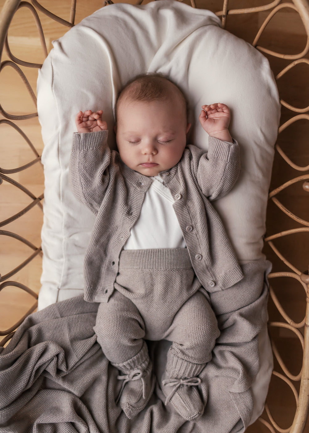 Baby med beige strikket babytæppe