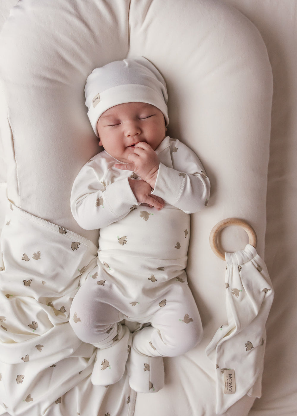 Baby med bidering i blødt stof med mønster