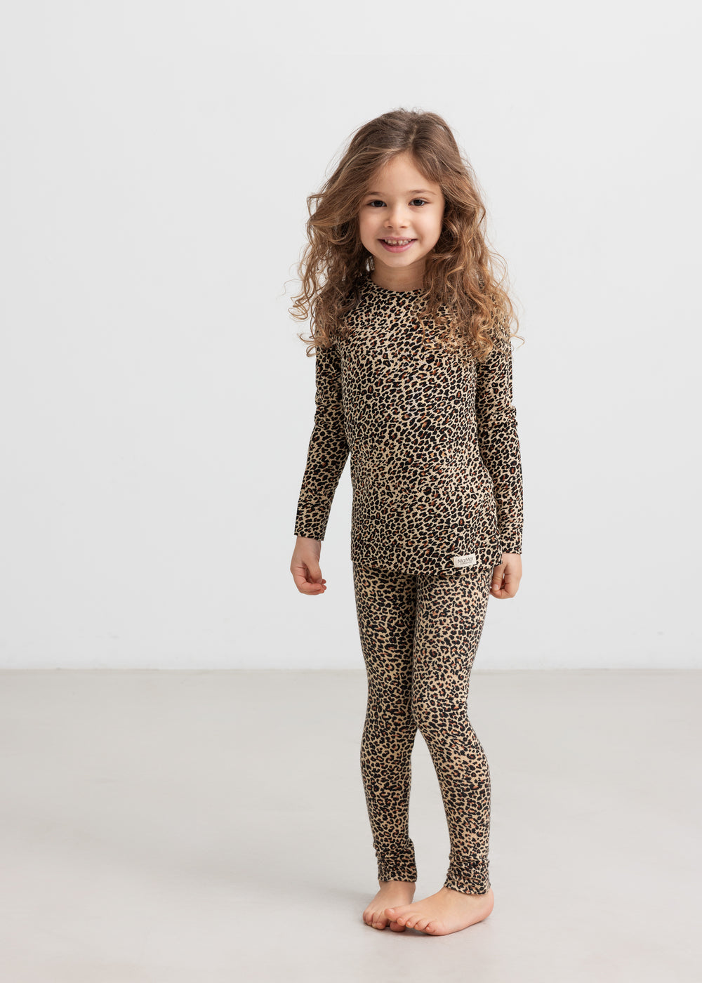 Pige i leggings og bluse i leopardprint