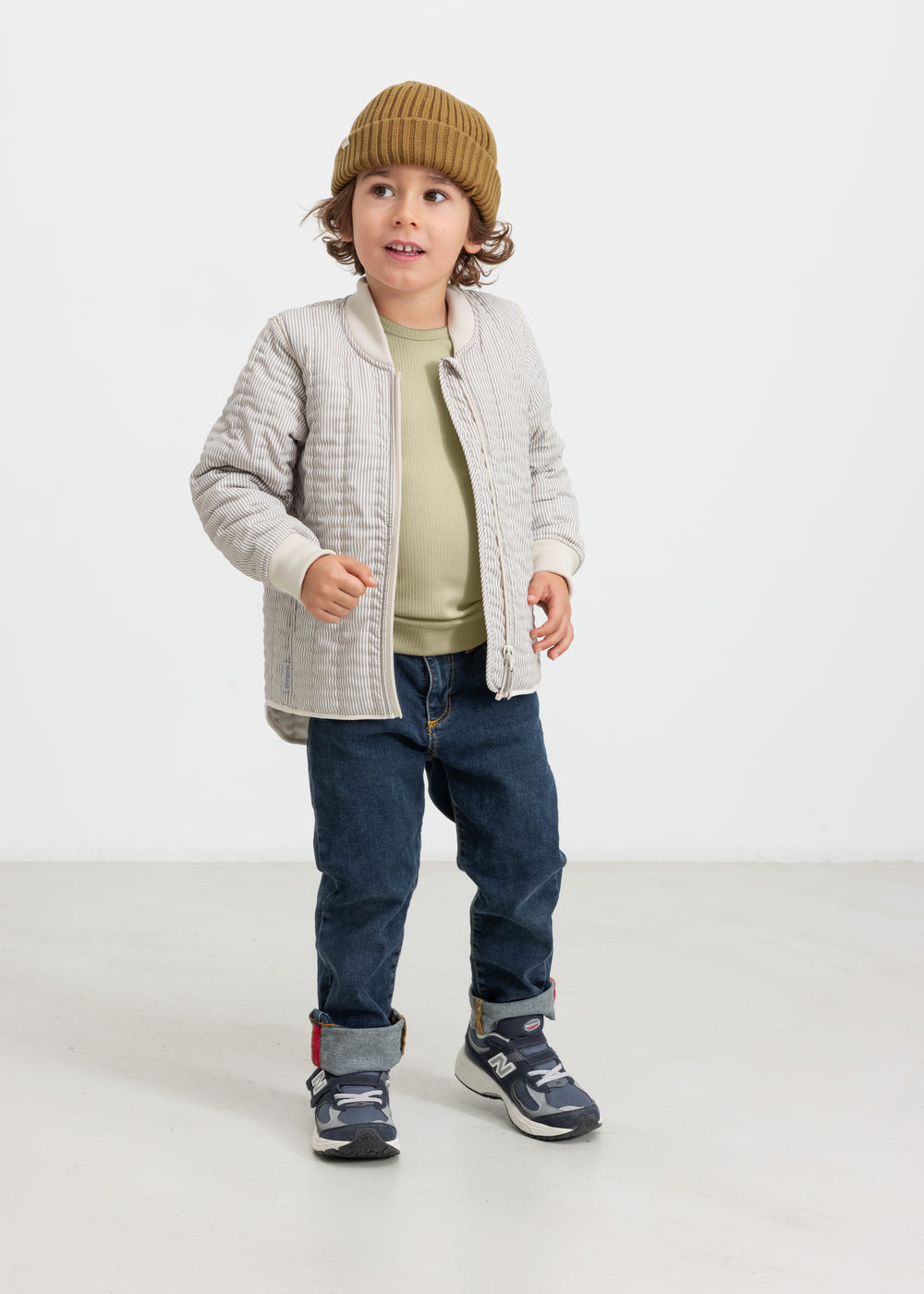 Barn iført brun strikket hue sammen med jeans og jakke