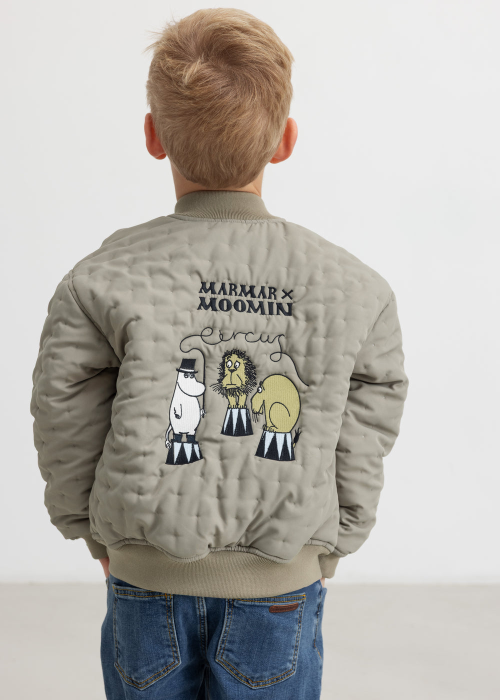 Barn set bagfra iført grøn jakke med Moomin print