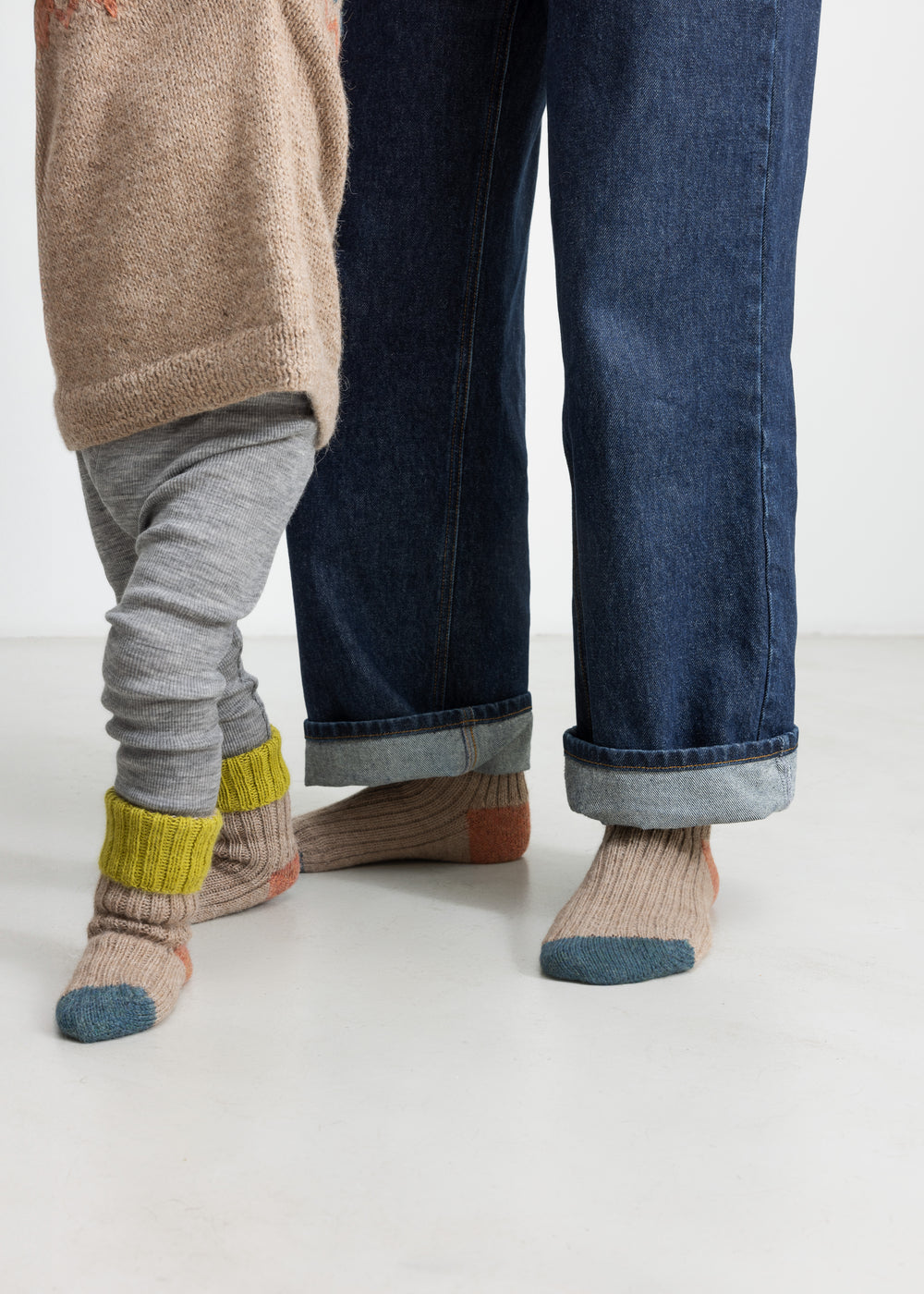 Børn iført uldstriksokker i beige med grøn rib