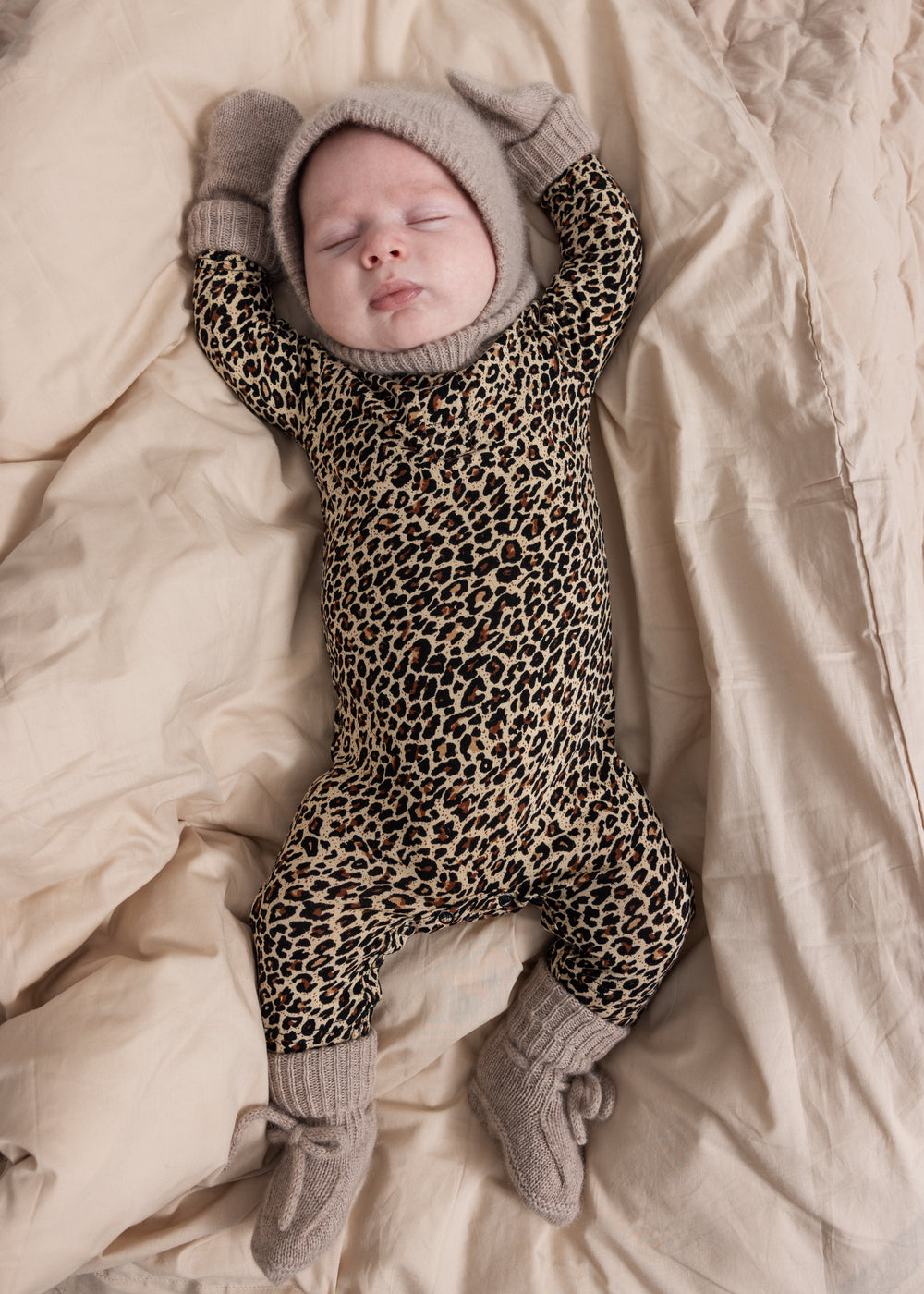 Grå meleret strikhue på baby med åbning ved ansigtet