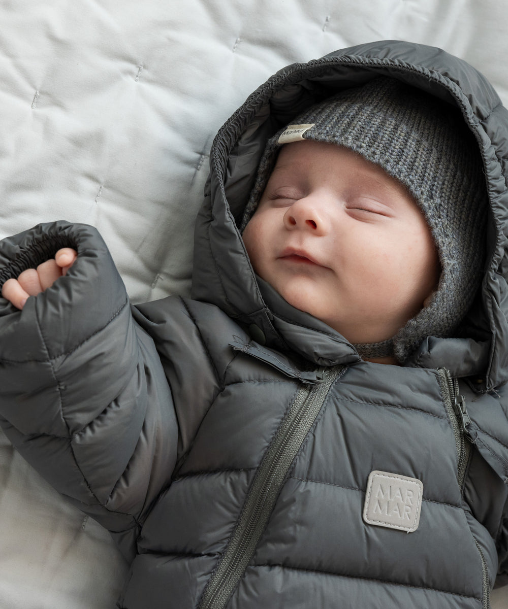 Sovende baby i mørkegrå dundragt med hætte og hue