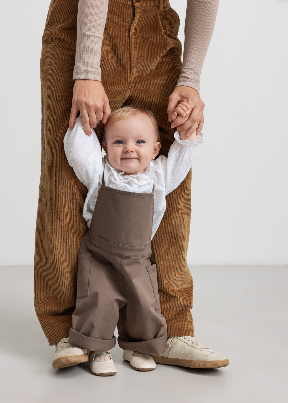 barn iført brune selebukser og hvid bluse