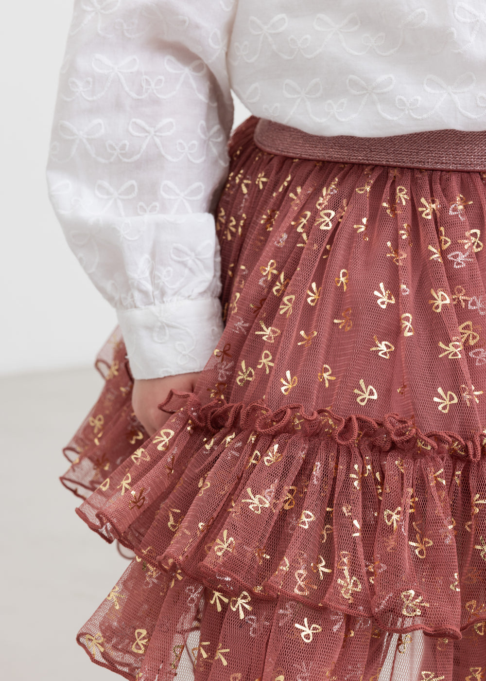 Nærbillede af rosa tylnederdel med flæser og gyldne detaljer til børn