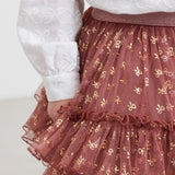 Nærbillede af rosa tylnederdel med flæser og gyldne detaljer til børn