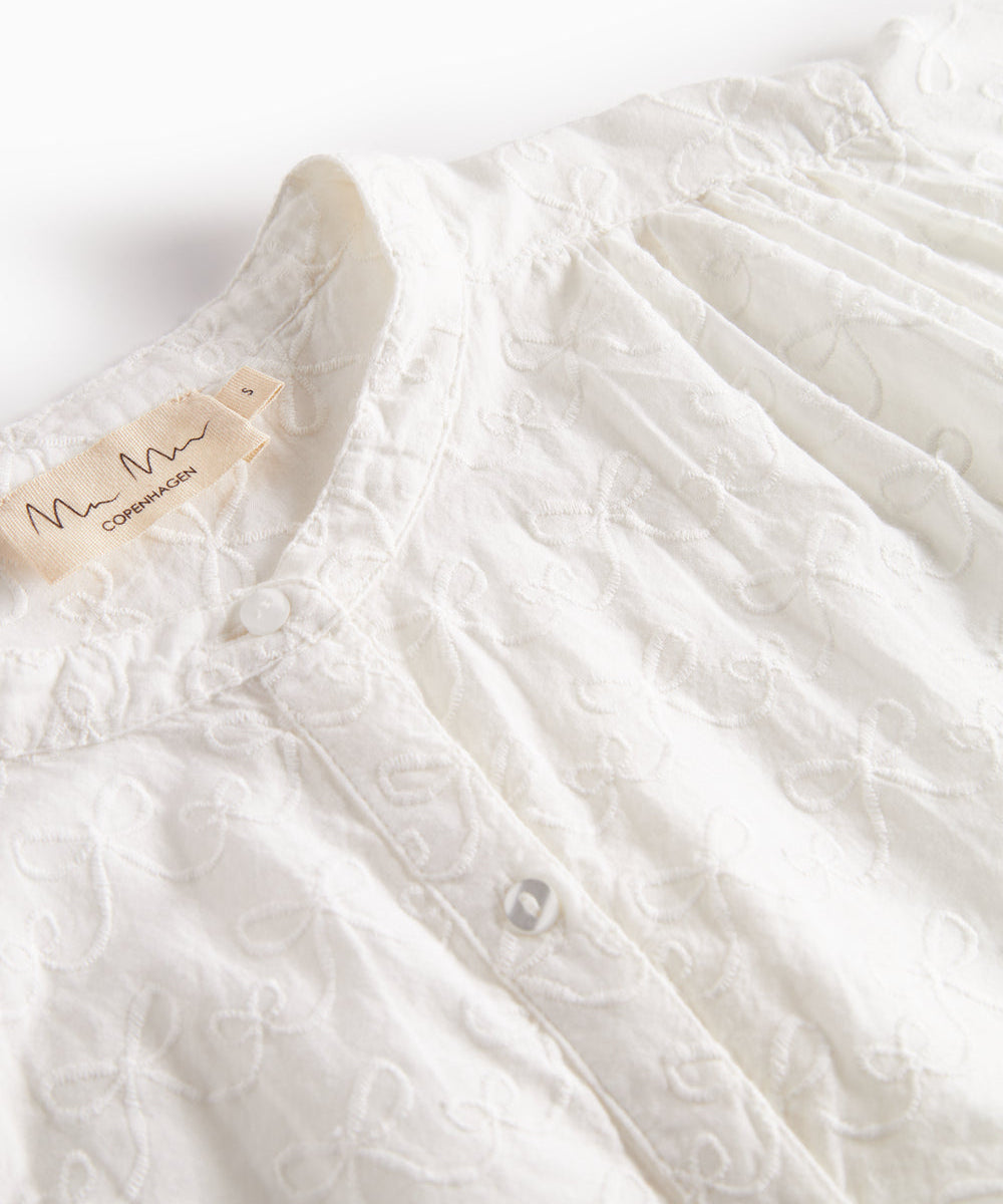 Detalje af blusens broderede mønster på brystet