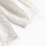 Detalje af blusens lange ærmer med broderede mønstre