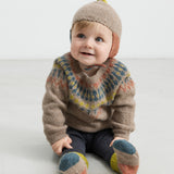 Baby iført beige uldstrikbluse med mønster og uldhue