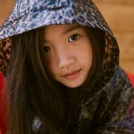 Barn iført leopardmønstret regnjakke me hætte