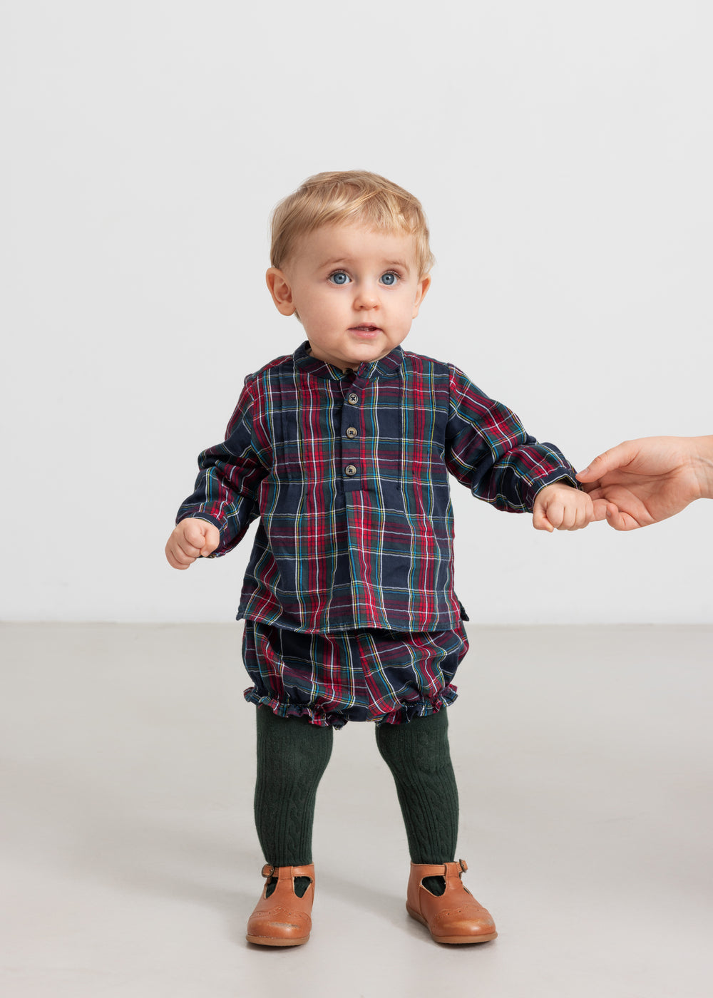 Baby iført mørkeblå og rød ternede bloomers og matchende juleskjorte
