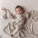 Baby ligger på baby tæppe med Moomin-print