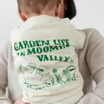 Baby iført råhvid t-shirt med grønt Moomin print