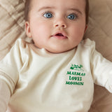 Baby iført råhvid t-shirt med grønt Moomin print
