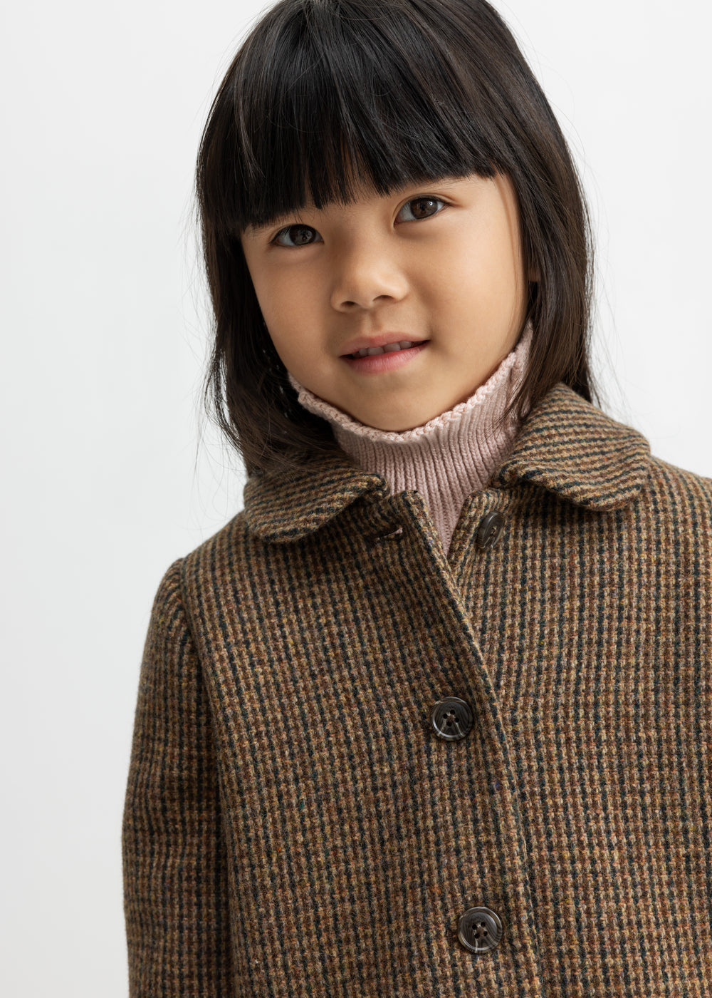 Barn i brun ternet uldfrakke med krave