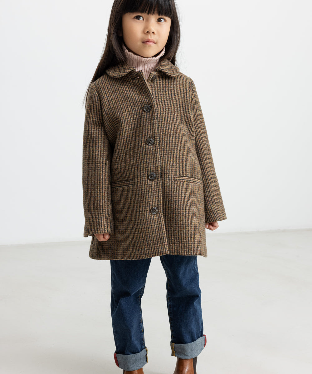 Pige iført brun ternet uldfrakke