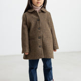 Pige iført brun ternet uldfrakke