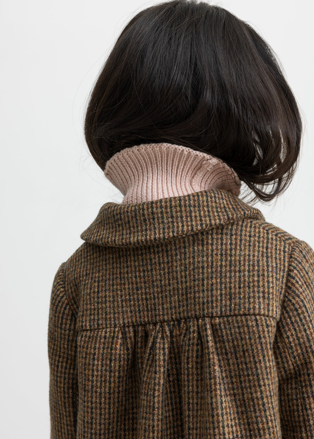 Detalje af ryg på brun ternet uldfrakke