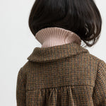 Detalje af ryg på brun ternet uldfrakke