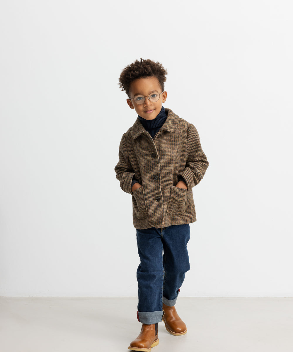 Dreng iført brun ternet jakke med krave