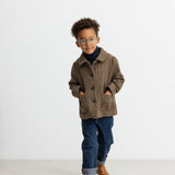 Dreng iført brun ternet jakke med krave