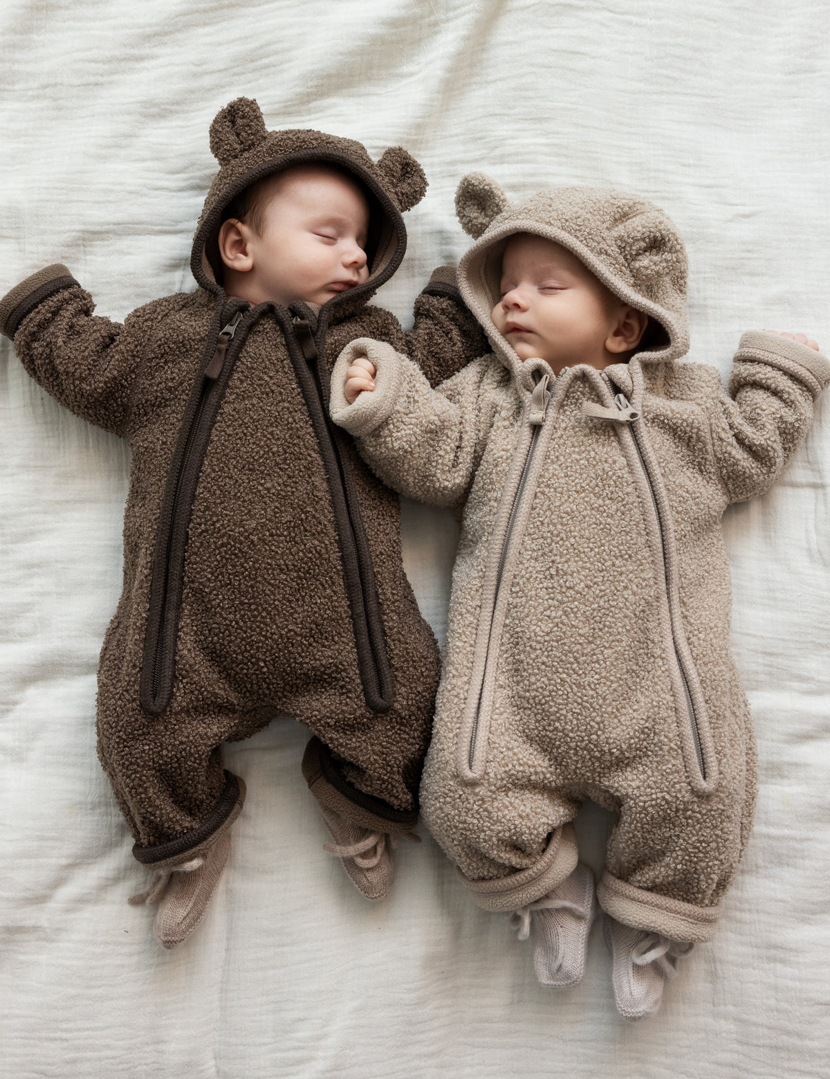 Nyfødte babyer i teddyfleece heldragter med hætte og ører