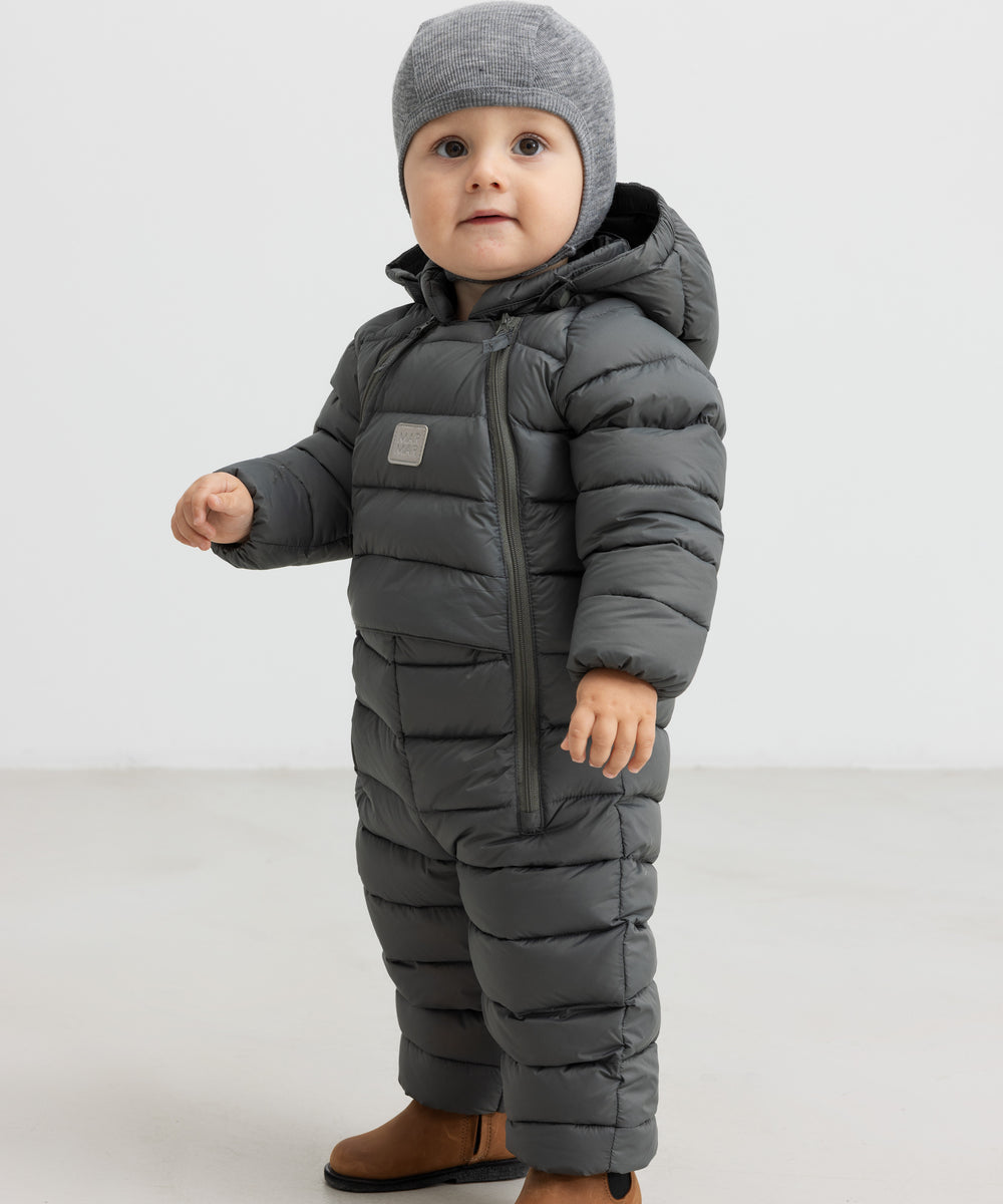 Baby iført mørkegrøn dundragt med hue