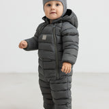 Baby iført mørkegrøn dundragt med hue