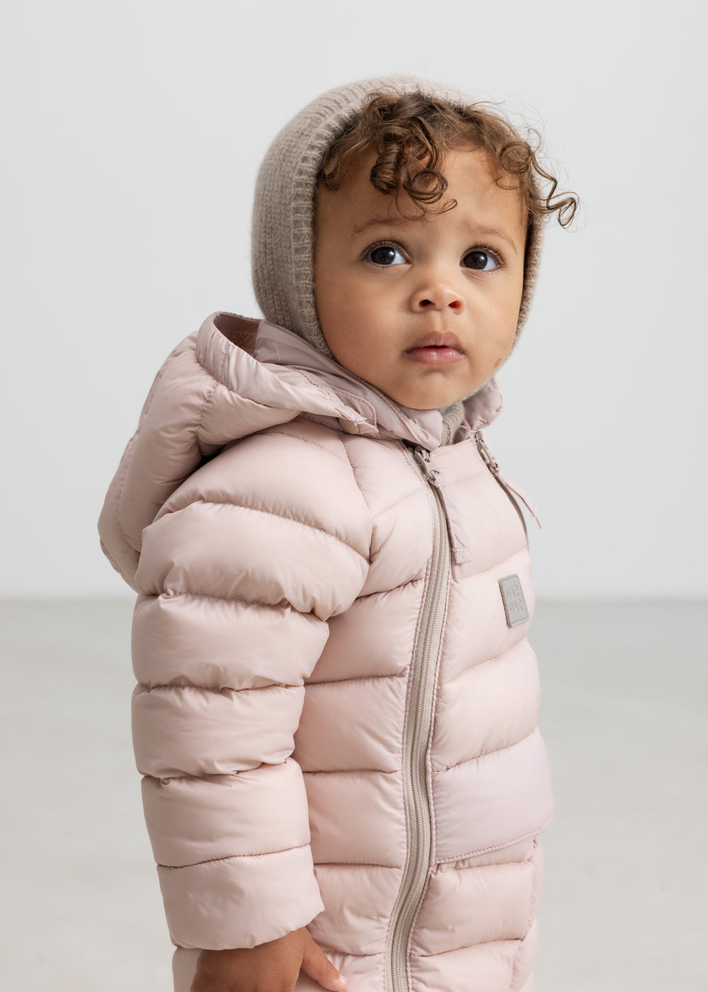 Lille børn iført lyserød dundragt med hætte