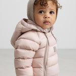 Lille børn iført lyserød dundragt med hætte