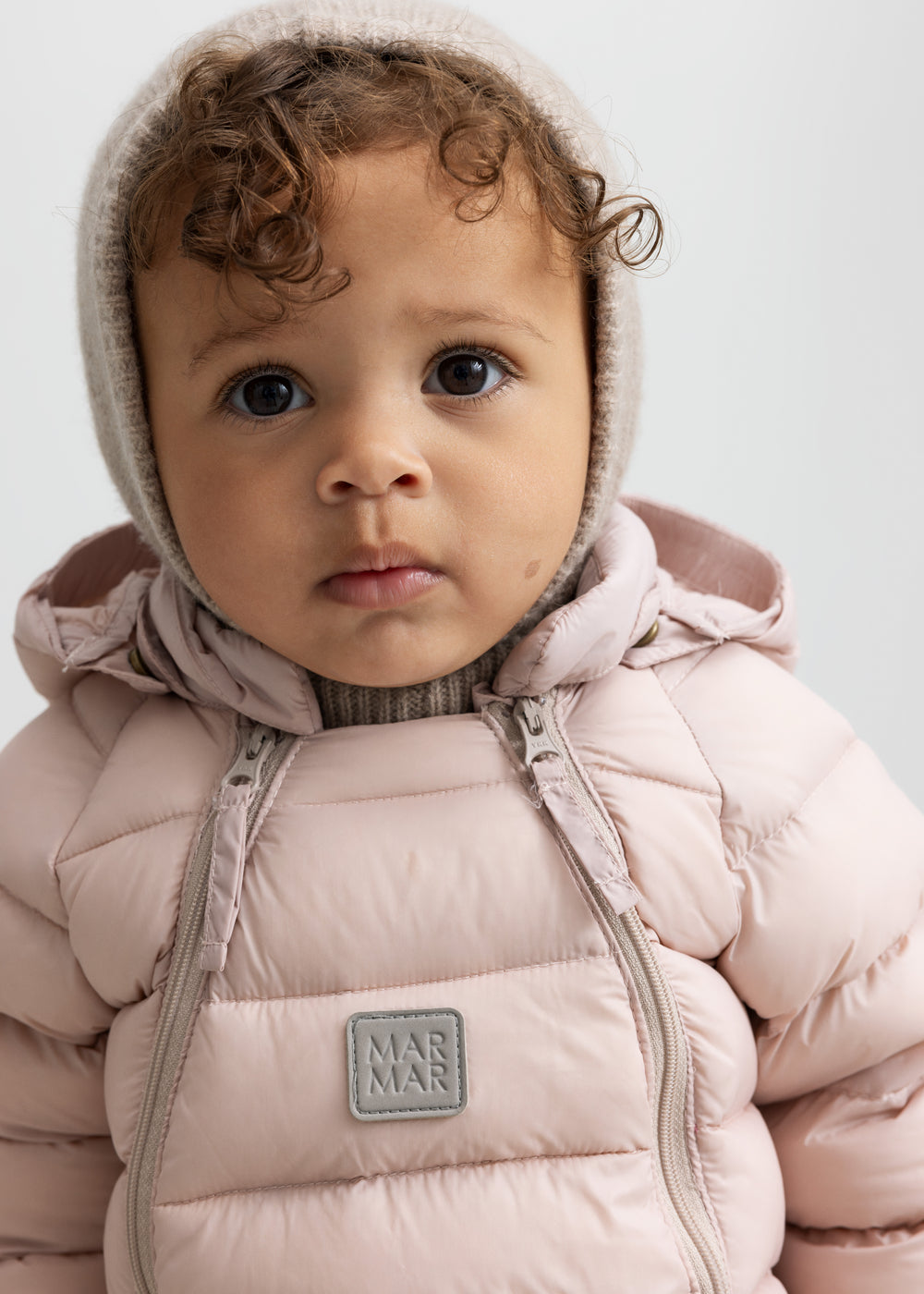 Lille børn iført lyserød dundragt med hætte