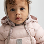 Lille børn iført lyserød dundragt med hætte