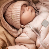 Baby iført lyserød dundragt og strikket hue