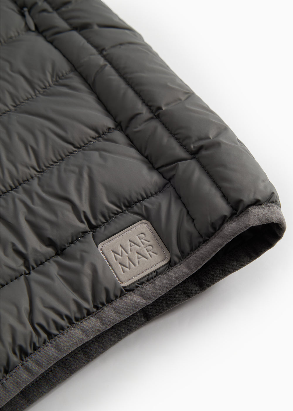 Logo og syninger på mørkegrå vatteret jakke