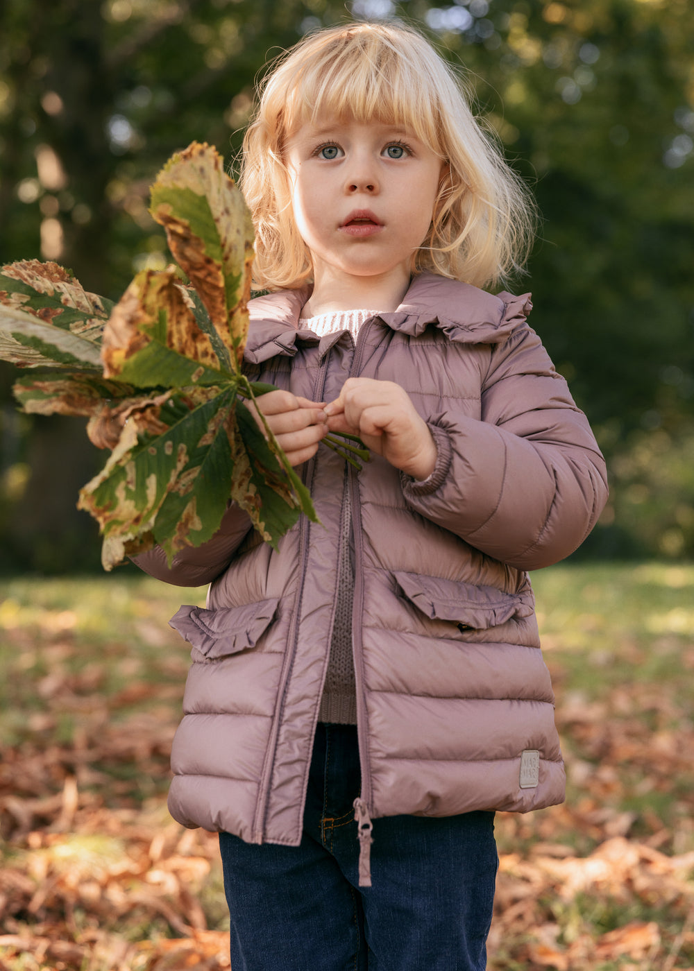 Pige i naturen iført rosa vatteret jakke med krave