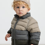 Barn iført beige strikhue og todelt dunjakke