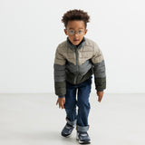 Dreng iført vatteret jakke i beige og grønne nuancer