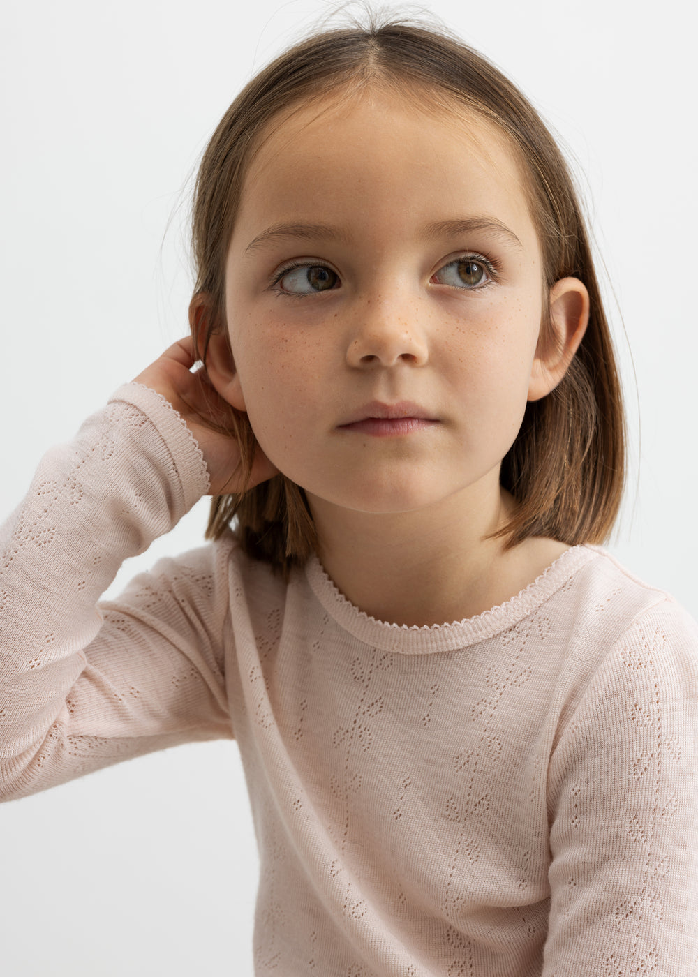 Pige iført lyserød bluse i merinould