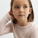 Pige iført lyserød bluse i merinould