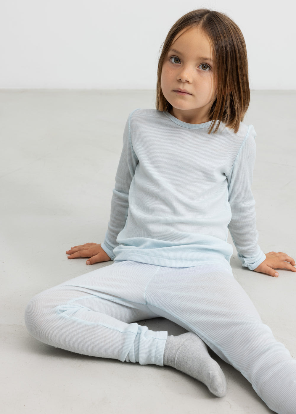 Børn iført lyseblå t-shirt og leggings i merinould