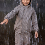 Barn iført brunt stribet regnsæt med hætte