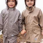 to børn i regntøj, venstre barn iført brunt stribet sæt med hætte