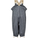 Børne-regnbukser i mørkeblå med små hvide blomster, justerbare seler og fodstropper