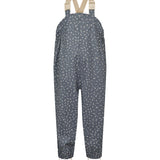 Børne-regnbukser i mørkeblå med små hvide blomster, justerbare seler og fodstropper