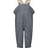 Børne-regnbukser i mørkeblå med små hvide blomster, justerbare seler og fodstropper