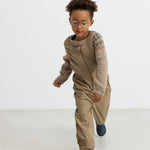 Dreng iført beige uldstrikbluse med mønster leger