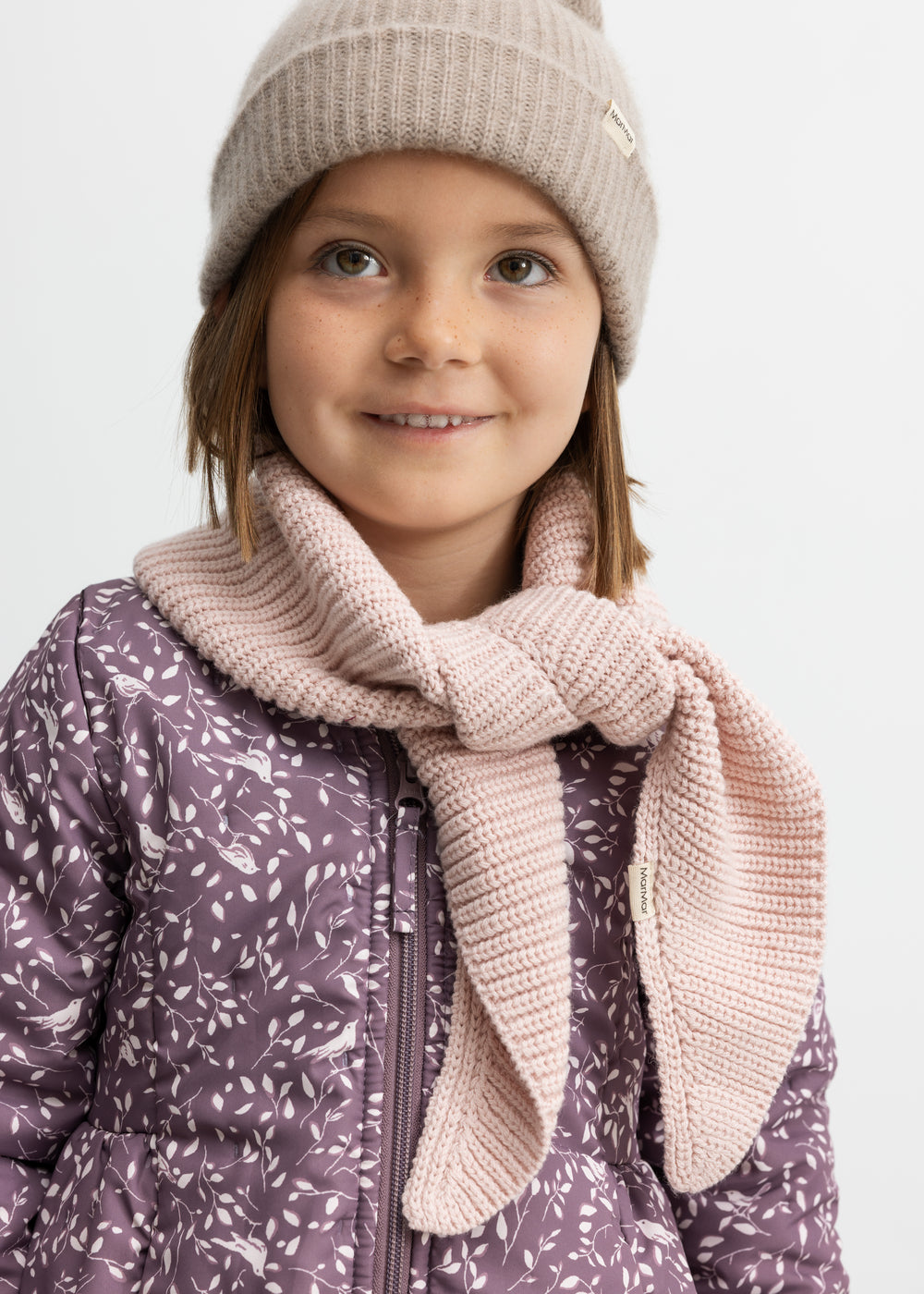 Barn iført lyserødt halstørklæde og hue