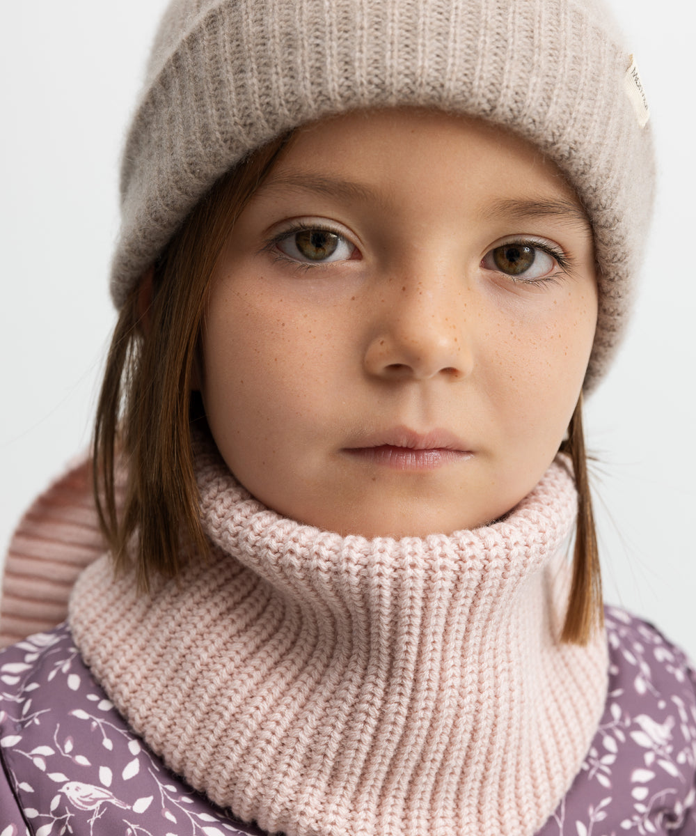 Barn iført lyserødt halstørklæde og hue