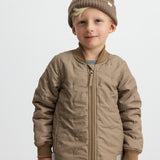 Barn iført brunternet termojakke og matchende bukser, smilende